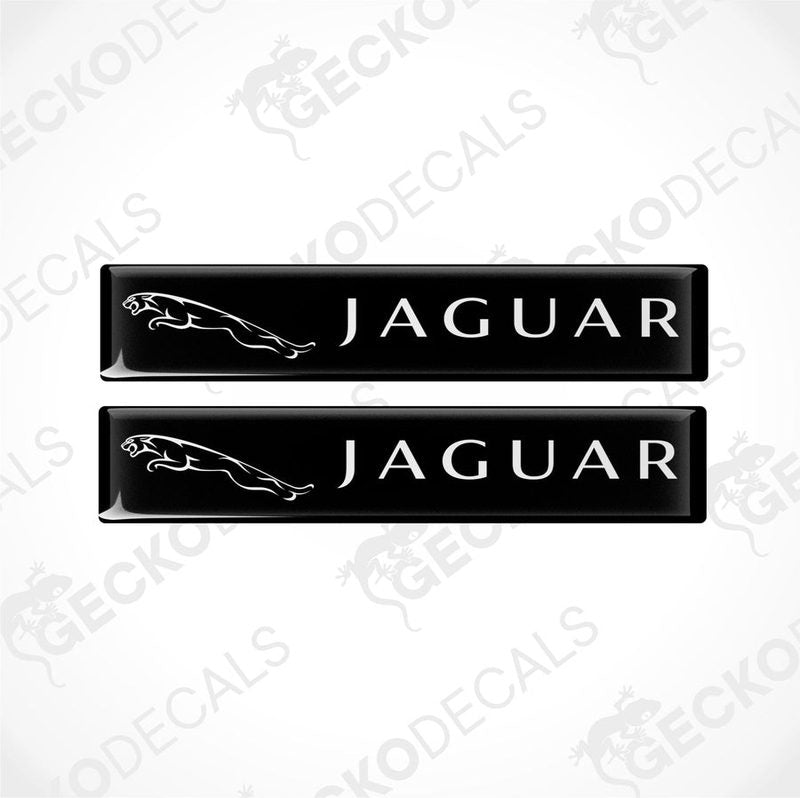 Two black rectangular car decals with the word 'JAGUAR' written on them in white lettering, along with the image of a jaguar in white.