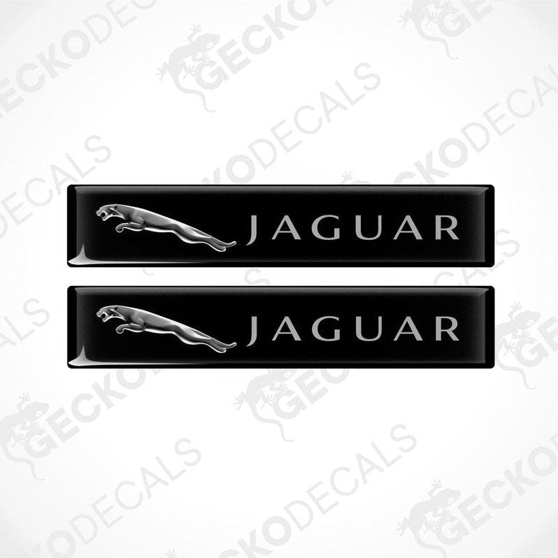 Two black rectangular car decals with the Jaguar brand logo and name written on them.