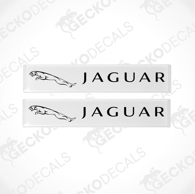 Two white rectangular car decals with the word 'JAGUAR' written on them in white lettering, along with the image of a jaguar in black.