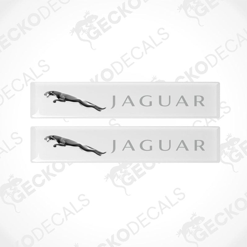 Two white rectangular car decals with the Jaguar brand logo and name written on them.