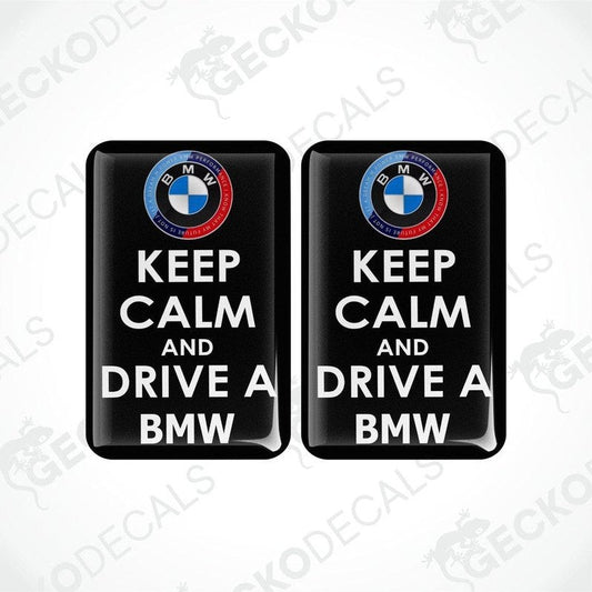 Two rectangular vinyl decals with a polyurethane coating, featuring the text 'KEEP CALM AND DRIVE A BMW' and the BMW logo.