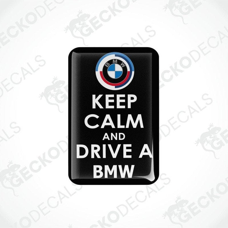 Rectangular black vinyl decals with the text 'KEEP CALM AND DRIVE A BMW' and the BMW logo in white and 