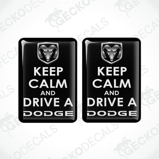 Two black vinyl decals with white text saying 'KEEP CALM AND DRIVE A DODGE' and the Dodge ram logo.
