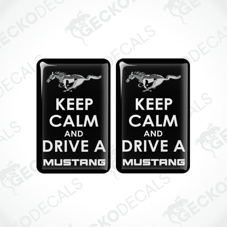 Two rectangular black vehicle decals with white text and graphics, one depicting a pony and the other the phrase 'KEEP CALM AND DRIVE A MUSTANG'.