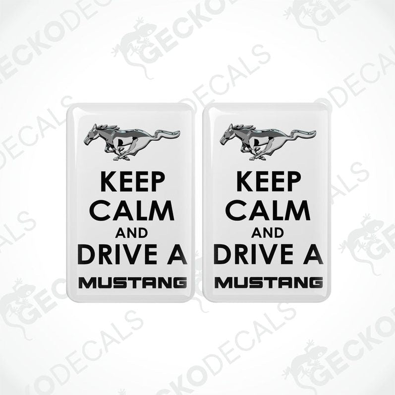 Two rectangular white vehicle decals with black text and graphics, one depicting a pony and the other the phrase 'KEEP CALM AND DRIVE A MUSTANG'.