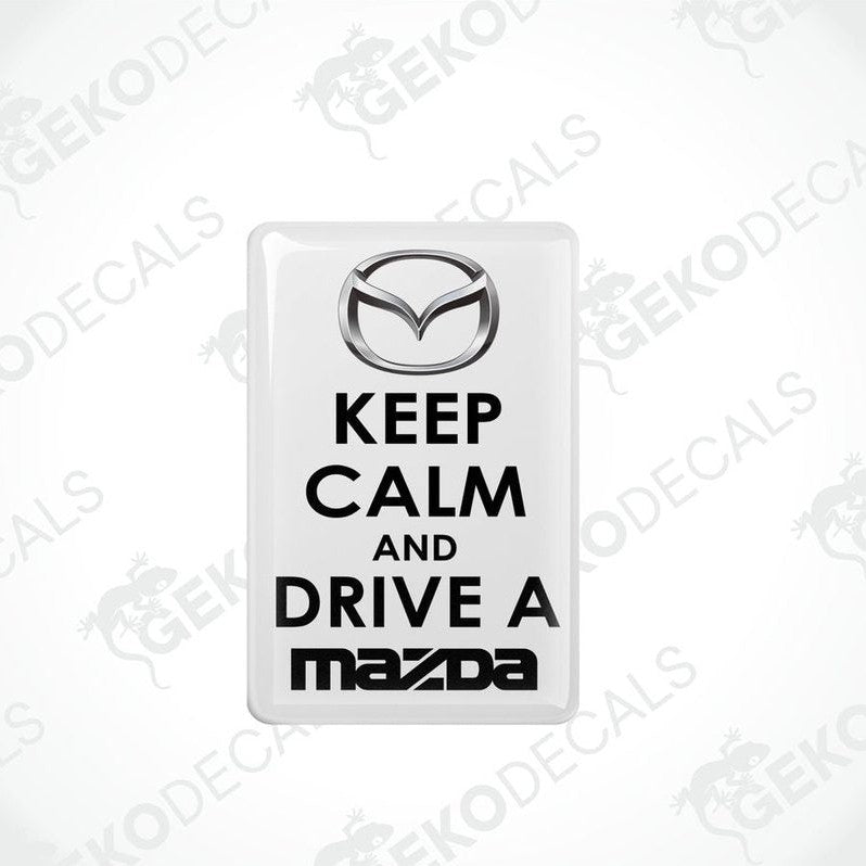 White vinyl stickers with the text 'KEEP CALM AND DRIVE A MAZDA' and the Mazda logo.