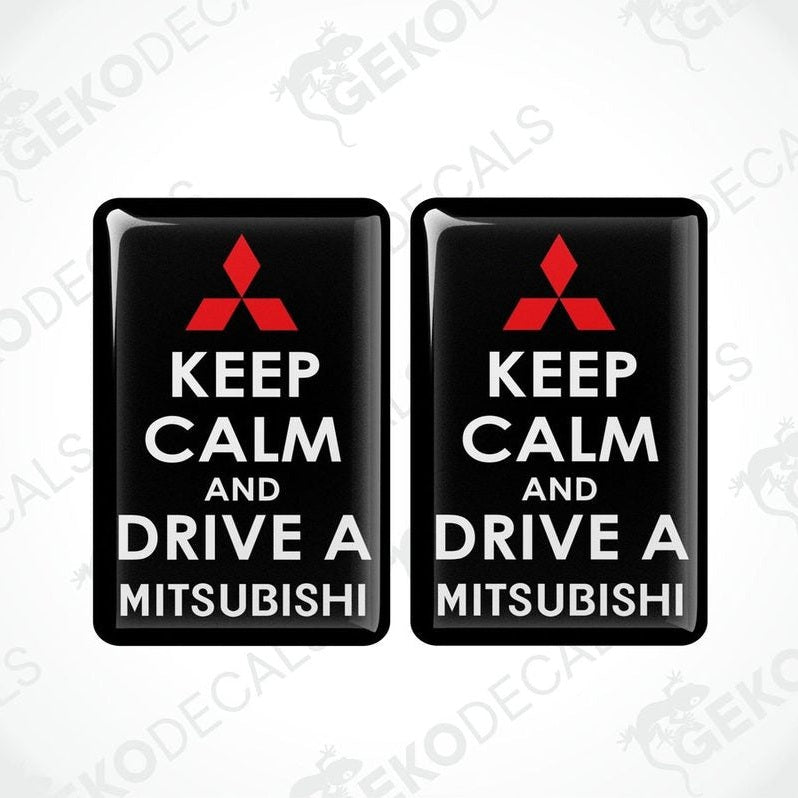 Two black vinyl stickers with the text 'KEEP CALM AND DRIVE A MITSUBISHI' and a white triangle logo on each sticker.