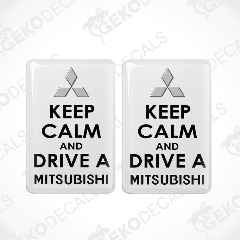 Two white vinyl stickers with the text 'KEEP CALM AND DRIVE A MITSUBISHI' and a black triangle logo on each sticker.