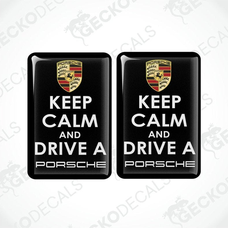 Two black vinyl decals with the text 'KEEP CALM AND DRIVE A PORSCHE' and the Porsche logo in white and yellow