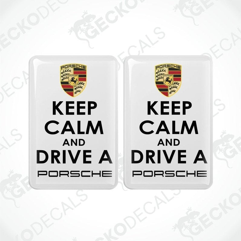  Two withe vinyl decals with the text 'KEEP CALM AND DRIVE A PORSCHE' and the Porsche logo in black and yellow
