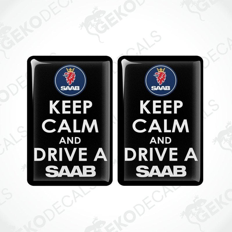 Two rectangular black vinyl decals with white text and the Saab car logo at the top, one decal saying 'KEEP CALM AND DRIVE A SAAB' and the other with a mirror image of the text and logo.