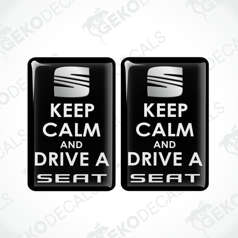 Two rectangular black vehicle decals with white text saying 'KEEP CALM AND DRIVE A SEAT'