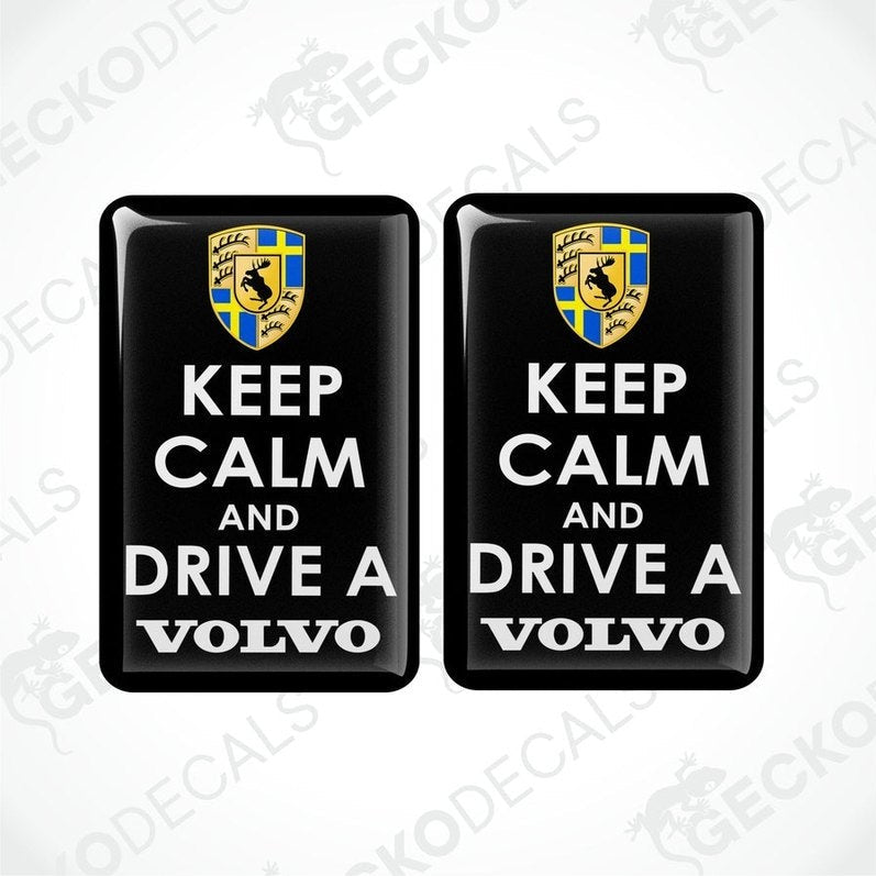 Two rectangular black vinyl decals with the text 'KEEP CALM AND DRIVE A VOLVO' in white letters, and the Volvo car logo in yellow and blue.
