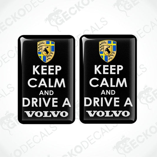 Two rectangular black vinyl decals with the text 'KEEP CALM AND DRIVE A VOLVO' in white letters, and the Volvo car logo in yellow and blue.