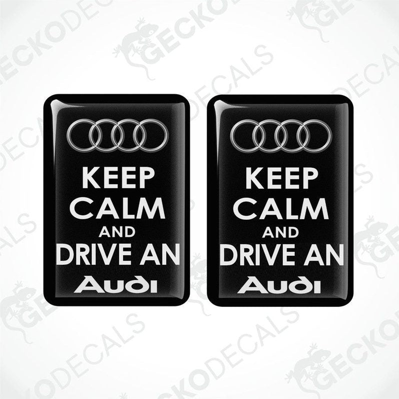 Two black vinyl stickers with the text 'KEEP CALM AND DRIVE AN AUDI' and the Audi logo.