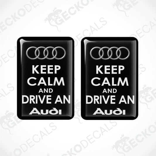 Two black vinyl stickers with the text 'KEEP CALM AND DRIVE AN AUDI' and the Audi logo.