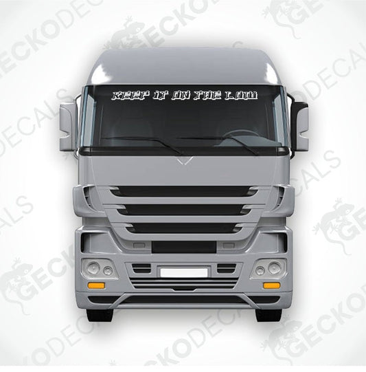 A decal with the text 'KEEP IT ON THE LOW' positioned on the windscreen of a gray truck.