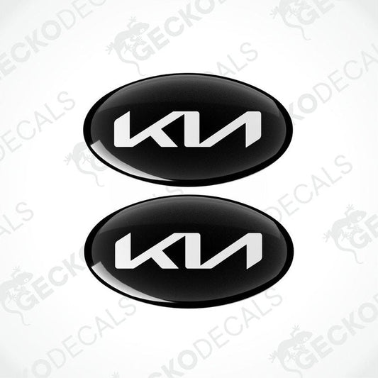 Two black oval-shaped vinyl decals with the KIA logo in white.