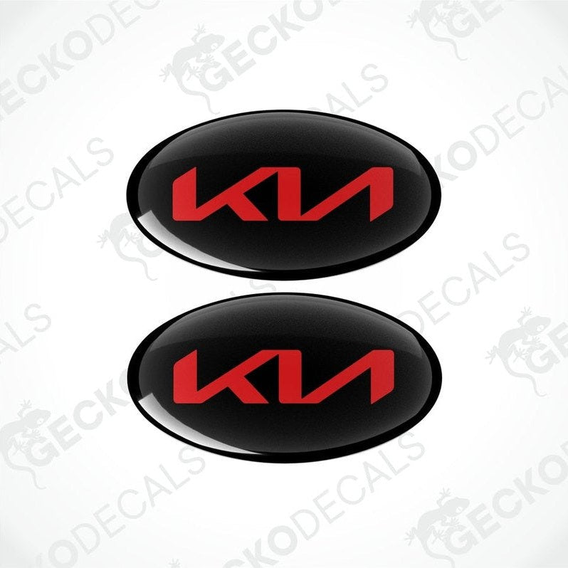 Two black oval-shaped vinyl decals with the KIA logo in red.