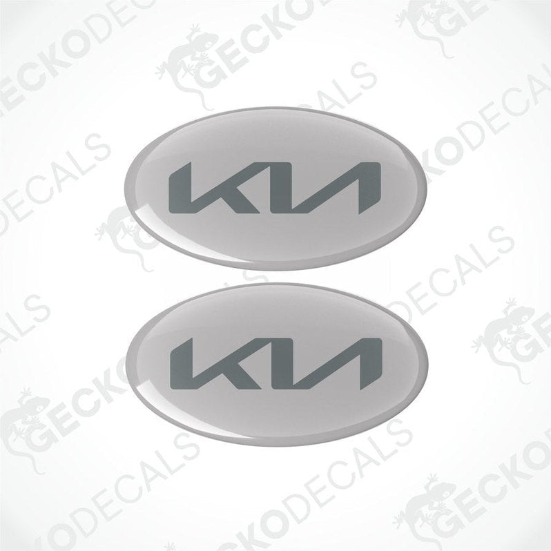 Two oval vinyl stickers grey a dark grey 'KIA' logo in the center, placed against a white background with the text 'geckodecals'.