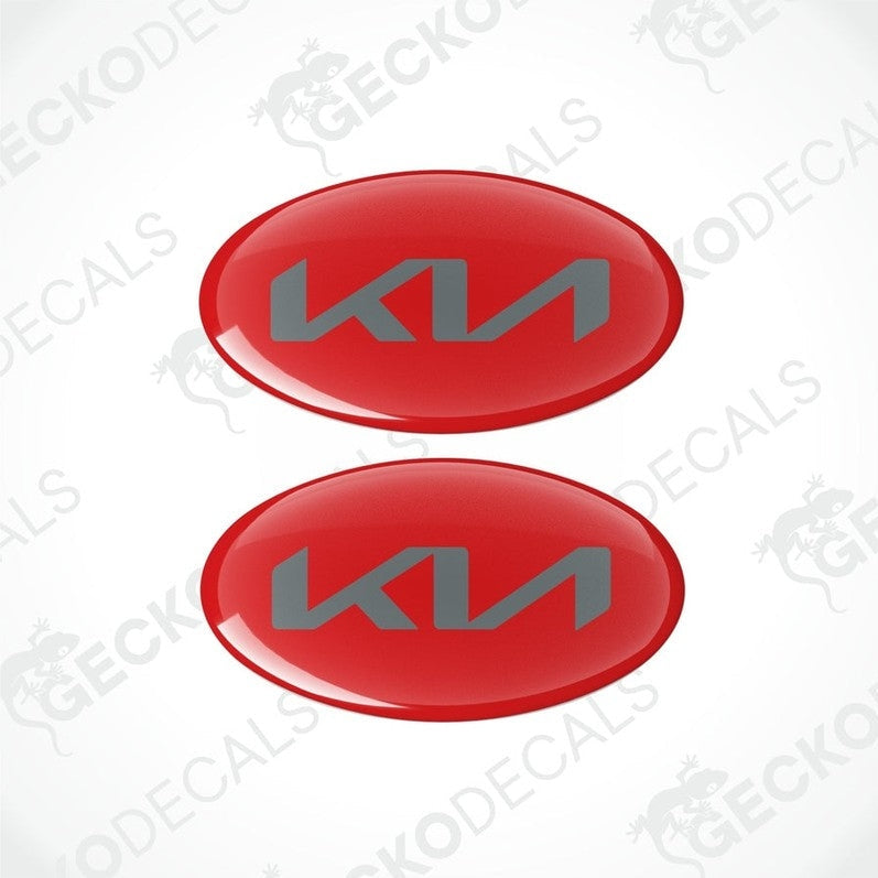 Two red oval-shaped vinyl decals with the KIA logo in grey.