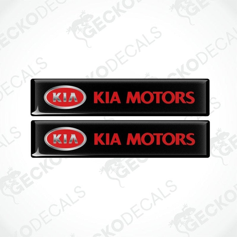 Two black vinyl stickers with the Kia Motors logo in red and white.