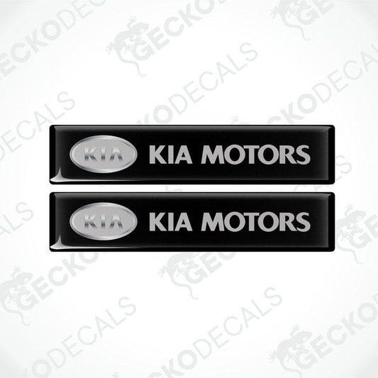 Two black rectangular car decals with 'KIA MOTORS' written in white text.