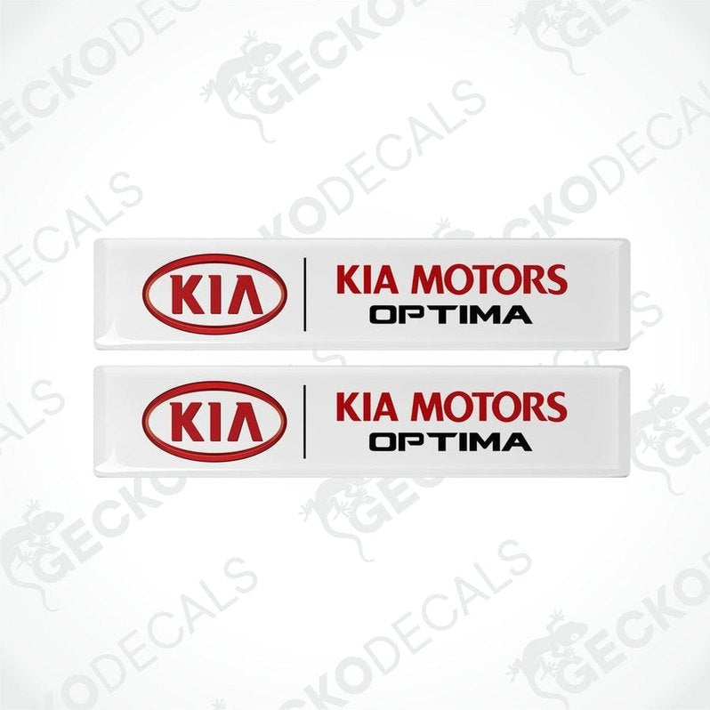 Two white vinyl decals with red text 'KIA MOTORS OPTIMA' on a white background.