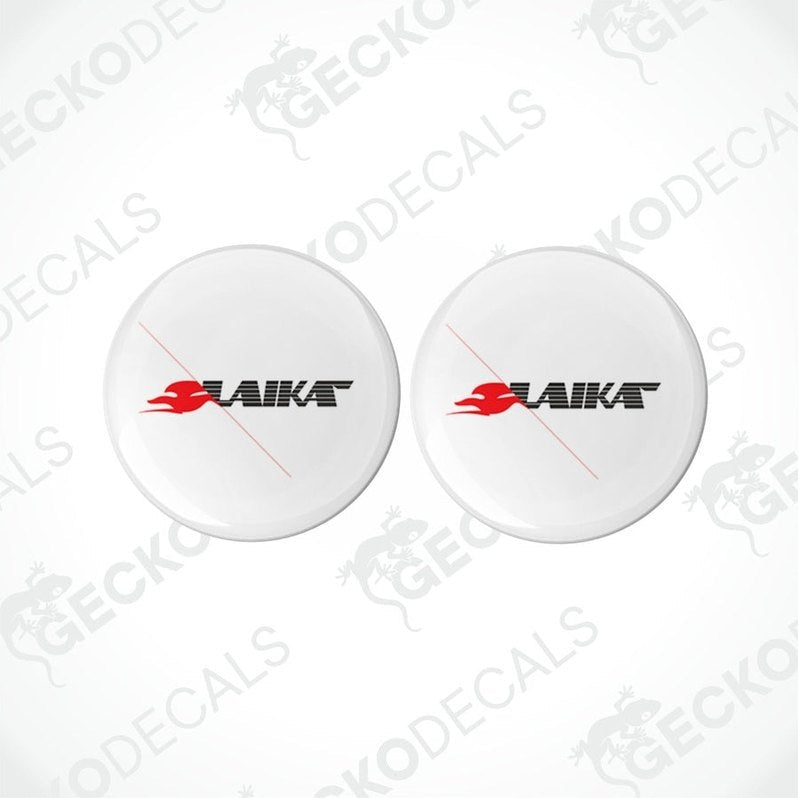 Two white round decals with the LAIKA brand logo in red and black, placed on a white background.