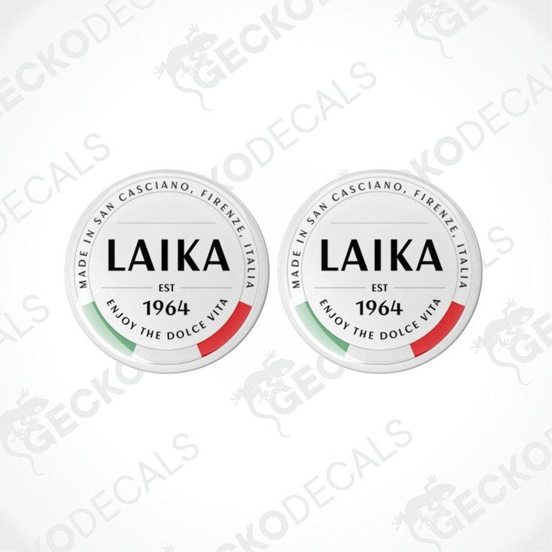 Two round white vinyl decals with 'LAika' branding and red and green accents, indicating they are from San Cassiano, Tuscany, Italy.