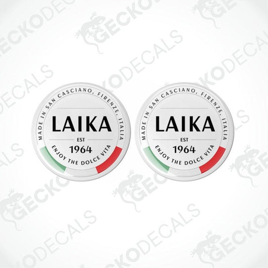 Two round white vinyl decals with 'LAika' branding and red and green accents, indicating they are from San Cassiano, Tuscany, Italy.
