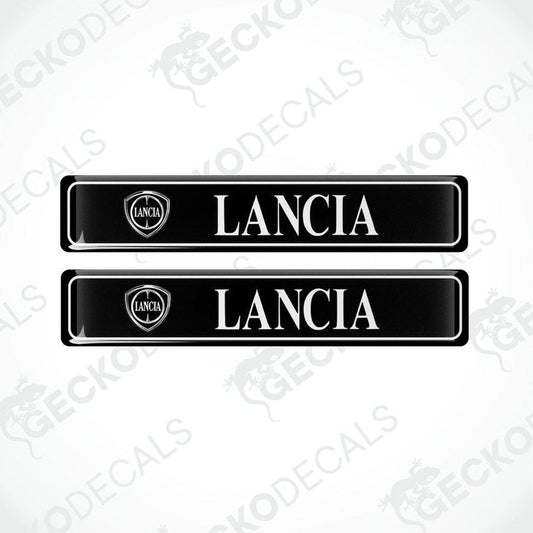 Two black vinyl stickers with 'LANCIA' text and a logo, placed against a white background.