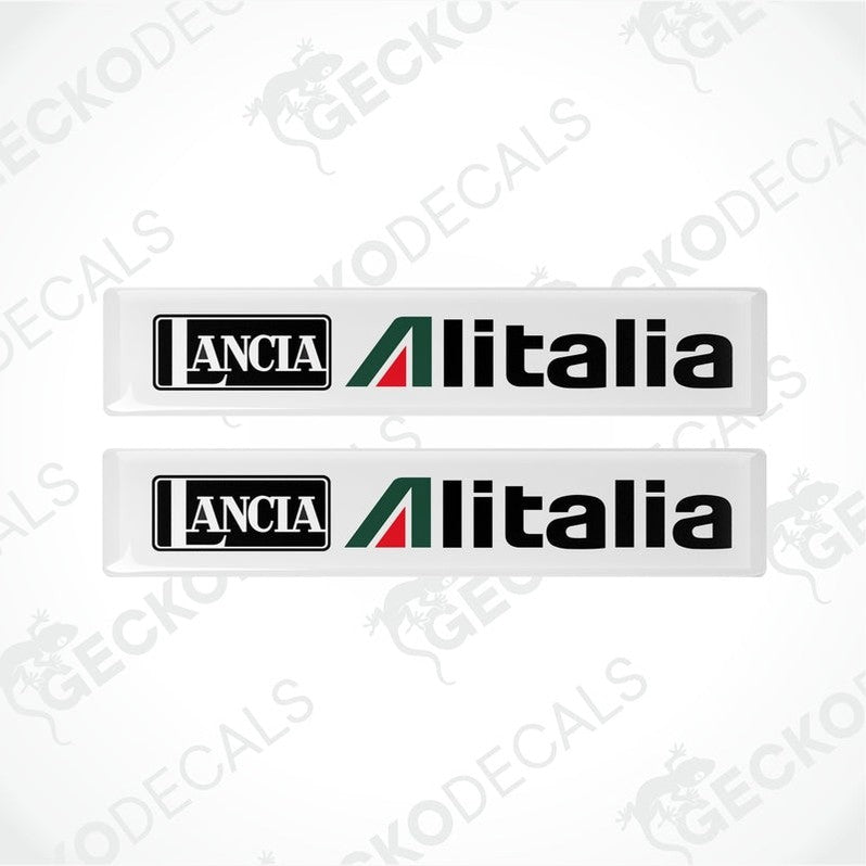 Two white vinyl stickers with green and red geometric patterns and the text 'LANCIA ALITALIA' printed on them.