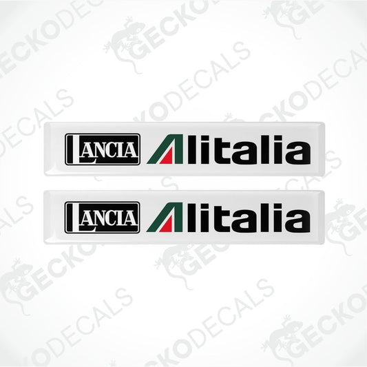 Two white vinyl stickers with green and red geometric patterns and the text 'LANCIA ALITALIA' printed on them.