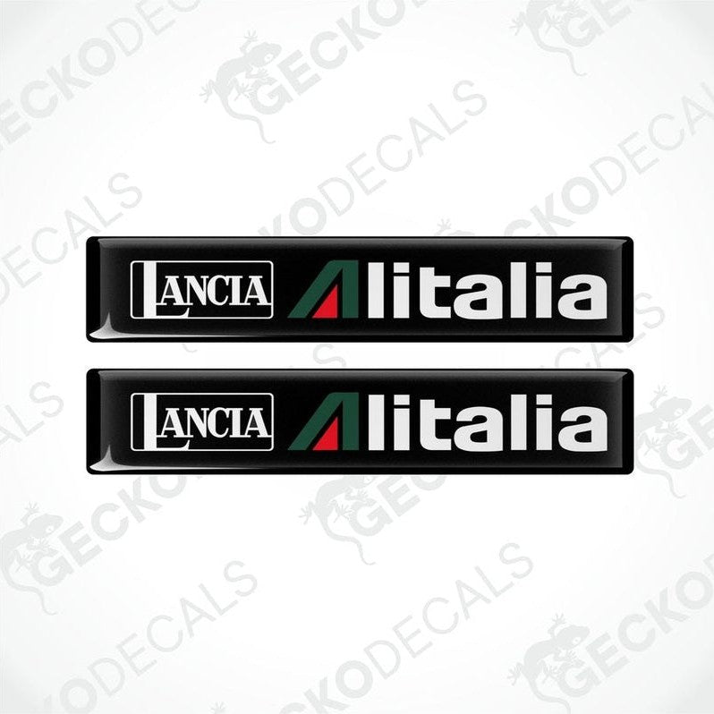 Two black vinyl stickers with green and red geometric patterns and the text 'LANCIA ALITALIA' printed on them.