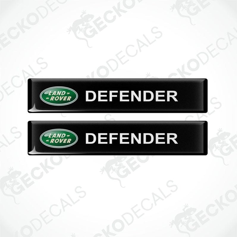 Two black vinyl decals with the text 'DEFENDER' and the Land Rover logo in green.