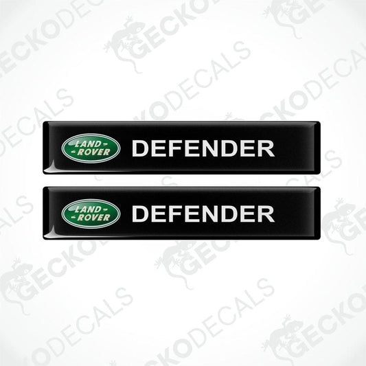 Two black vinyl decals with the text 'DEFENDER' and the Land Rover logo in green.