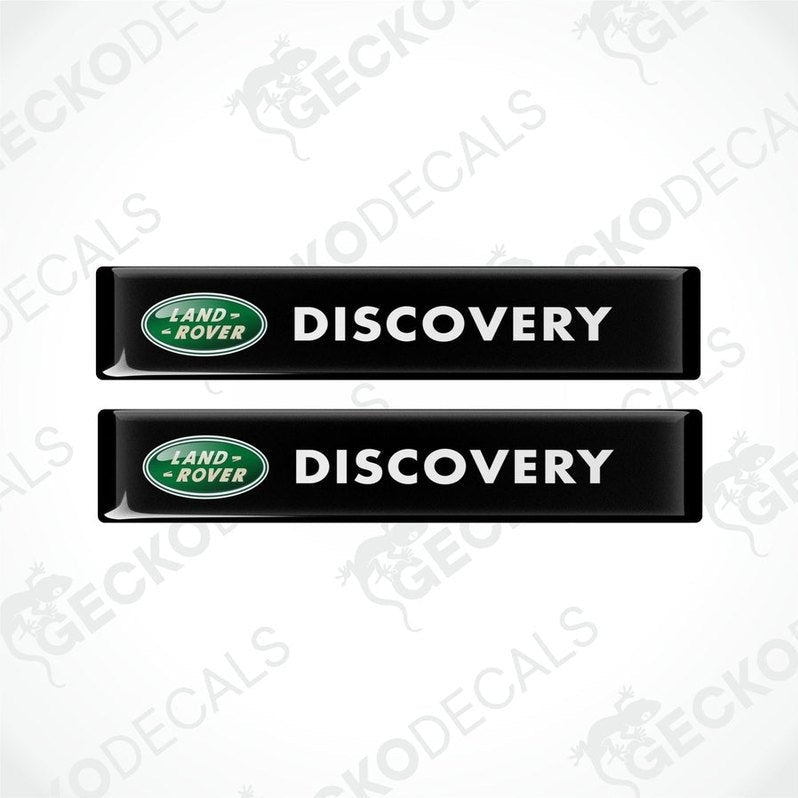 Two black vinyl decals with the text 'DISCOVERY' and the Land Rover logo in green and white.