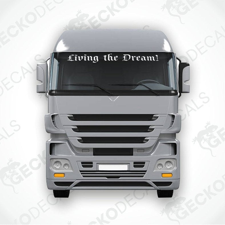 A decal with the phrase 'Living the Dream!' displayed on the windscreen of a truck.