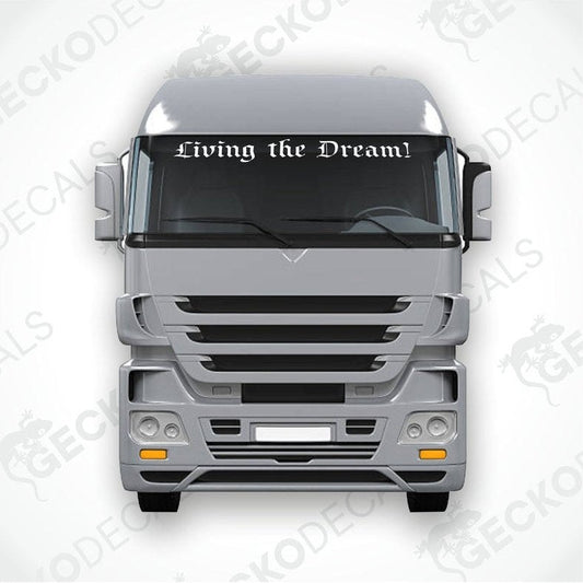 A decal with the phrase 'Living the Dream!' displayed on the windscreen of a truck.