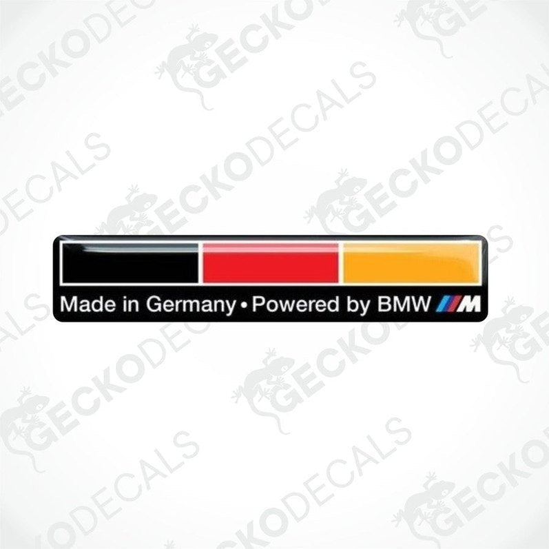 Vinyl decals with 'MADE IN GERMANY POWERED BY BMW' text, one in black with a red border, and one in yellow with a black border.