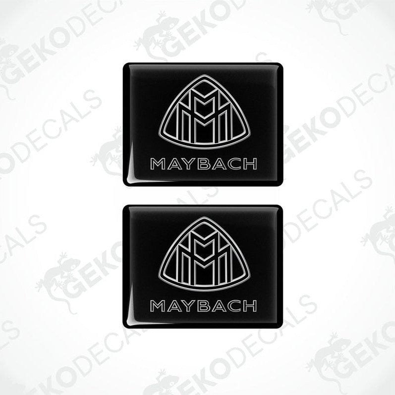Two black vinyl stickers with a white geometric design representing the Maybach brand logo.