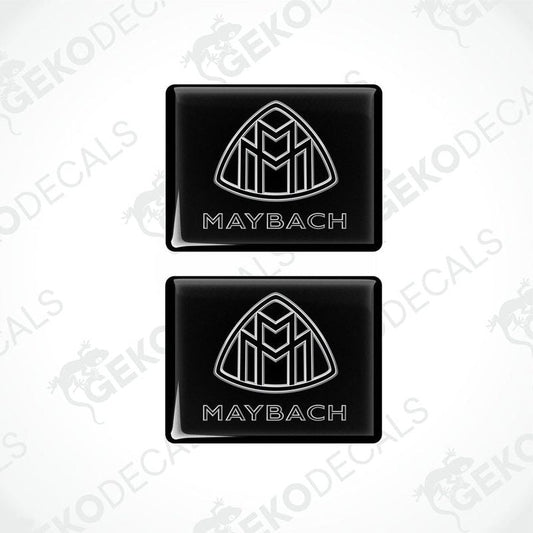 Two black vinyl stickers with a white geometric design representing the Maybach brand logo.
