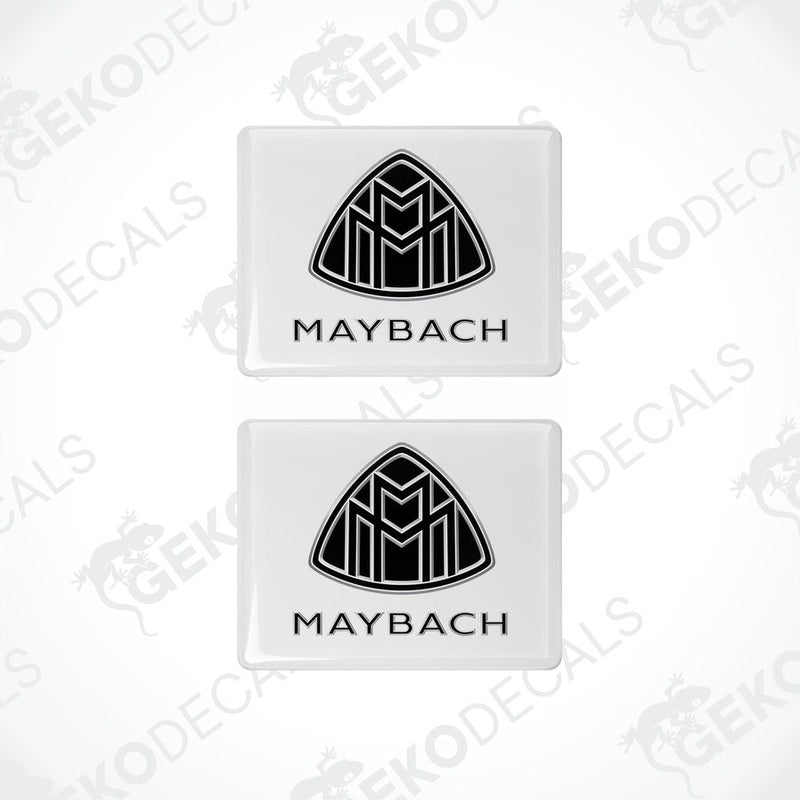 Two white vinyl stickers with a black geometric design representing the Maybach brand logo.