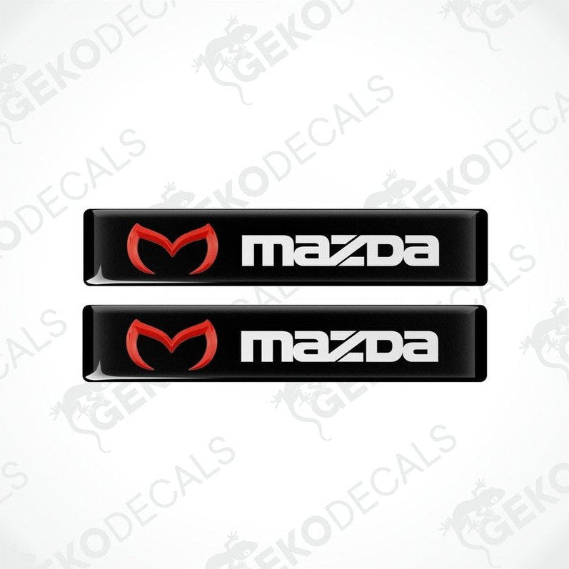 Two black vinyl stickers with a red and white Mazda logo on them.