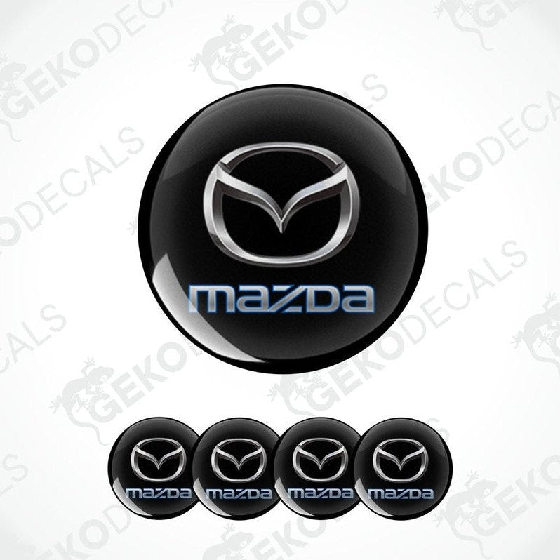A set of black round car decals with the Mazda logo in the center and smaller copies of the logo on the sides.