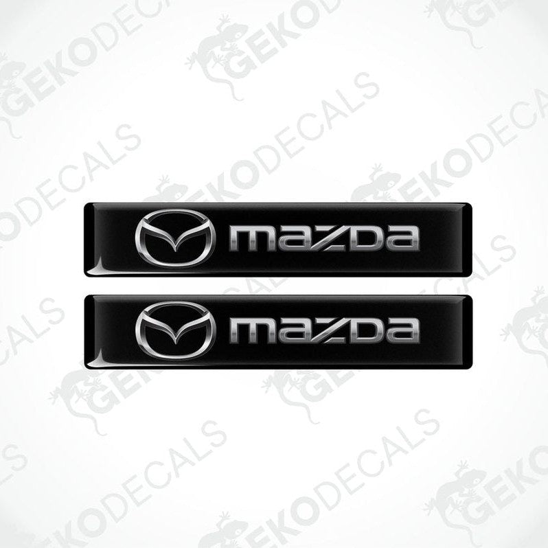 Two black vinyl stickers with the Mazda logo in the center.
