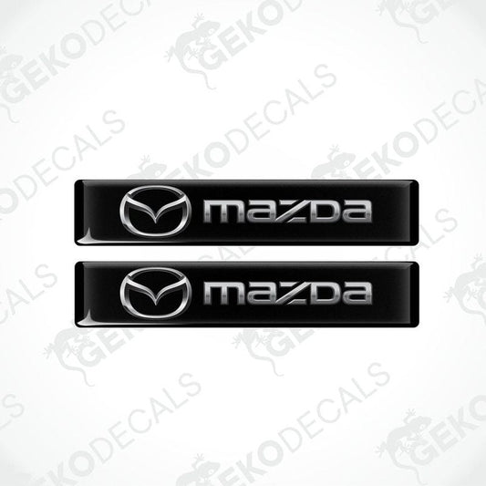 Two black vinyl stickers with the Mazda logo in the center.