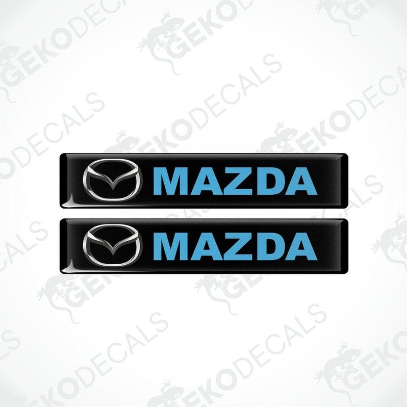 Two black, blue, and silver Mazda branded vinyl decals.