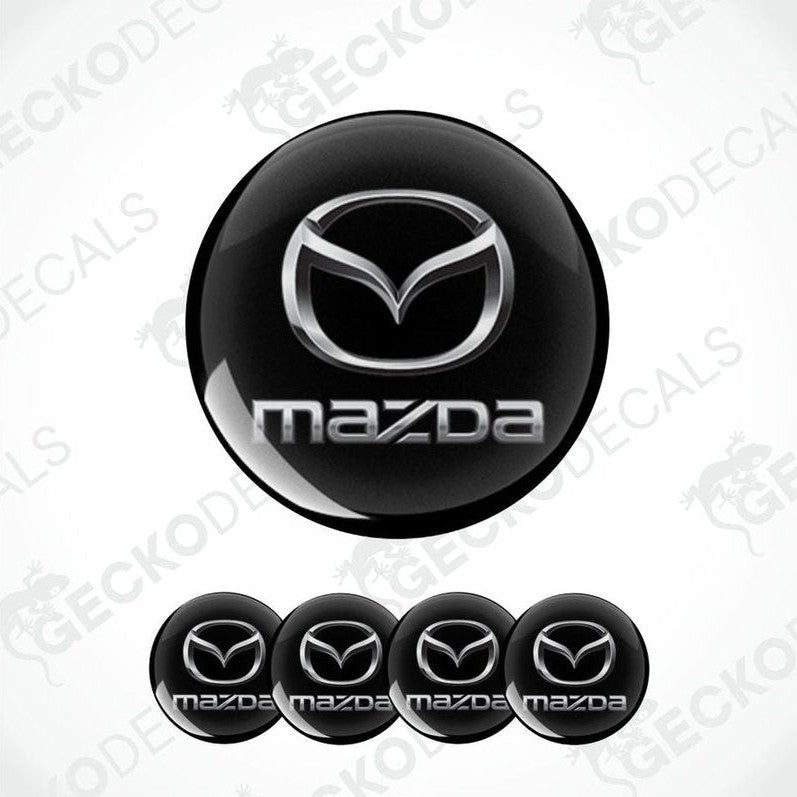 Set of Mazda logos on black round stickers with a white background.